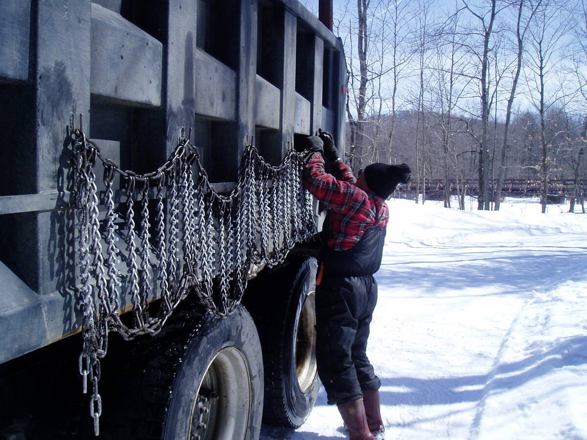 Logger chaining up a truck in winter